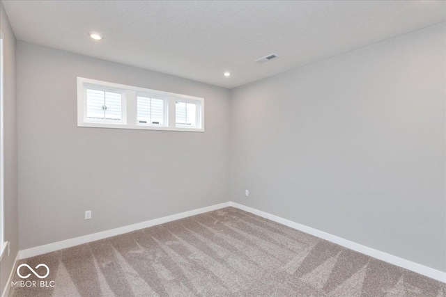 unfurnished room featuring a textured ceiling and carpet floors