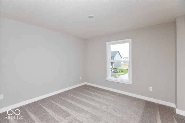 carpeted spare room featuring a textured ceiling