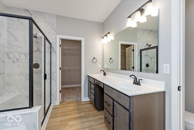 bathroom featuring hardwood / wood-style floors, vanity, and a shower with door