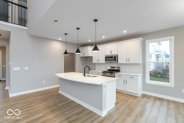 kitchen featuring white cabinets, pendant lighting, stainless steel appliances, and sink