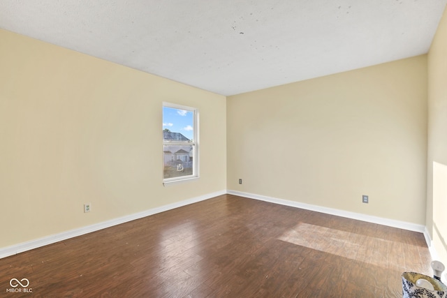 unfurnished room with baseboards and wood finished floors