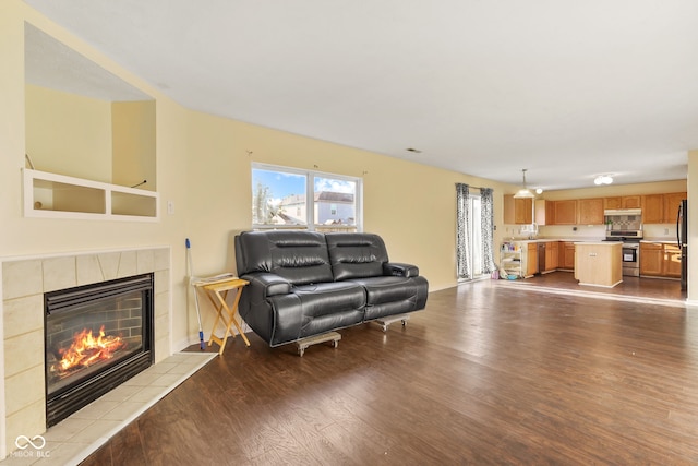 living room with a tile fireplace and light wood-style flooring