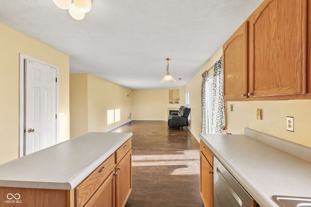 kitchen featuring a center island, hanging light fixtures, stainless steel dishwasher, and dark hardwood / wood-style floors