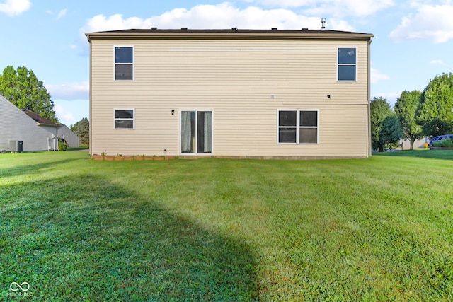 rear view of house featuring a lawn and central air condition unit