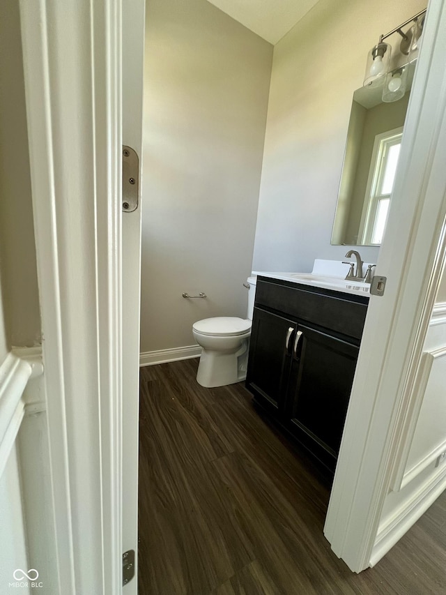 bathroom with wood-type flooring, vanity, and toilet