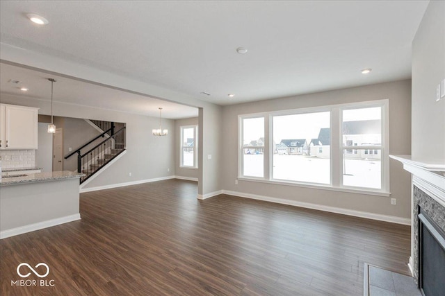 unfurnished living room featuring a chandelier and dark hardwood / wood-style flooring