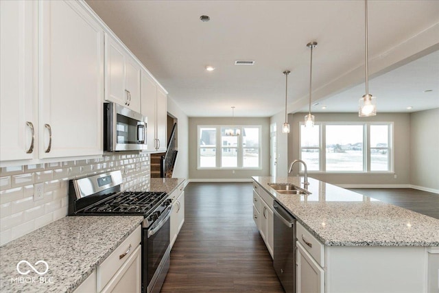 kitchen with tasteful backsplash, an island with sink, white cabinetry, sink, and stainless steel appliances