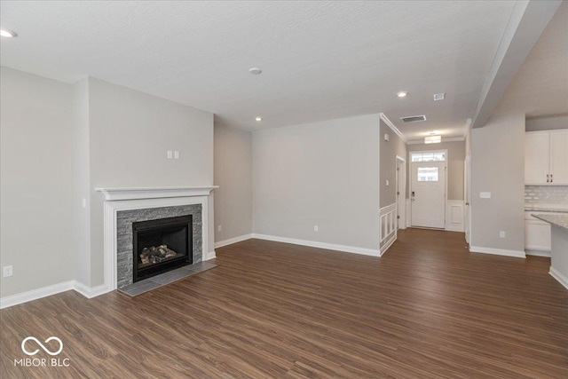 unfurnished living room featuring dark wood-type flooring and a textured ceiling