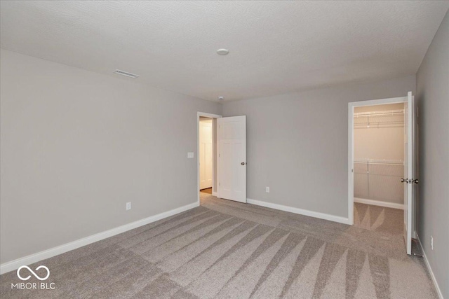 empty room featuring light colored carpet and a textured ceiling