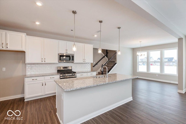 kitchen featuring a kitchen island with sink, stainless steel appliances, and white cabinets