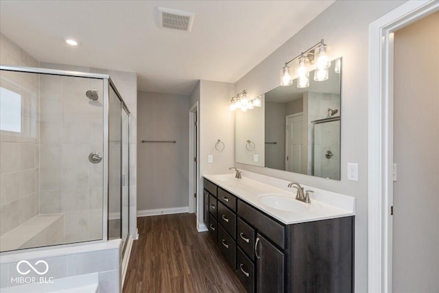 bathroom featuring hardwood / wood-style flooring, vanity, and an enclosed shower