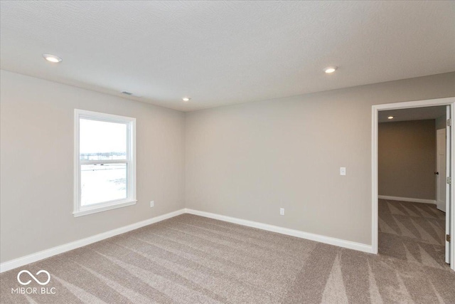 carpeted empty room with a textured ceiling