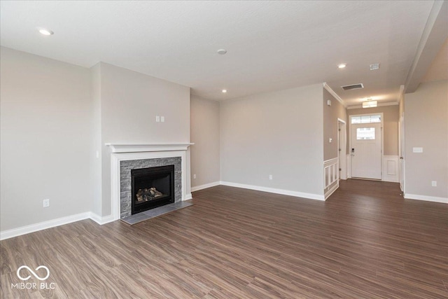 unfurnished living room with visible vents, baseboards, recessed lighting, a stone fireplace, and dark wood-type flooring