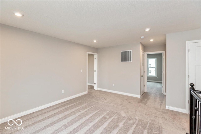 unfurnished room featuring recessed lighting, visible vents, baseboards, and light carpet