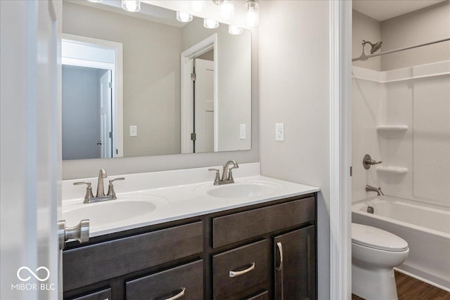 bathroom featuring toilet, washtub / shower combination, a sink, and double vanity