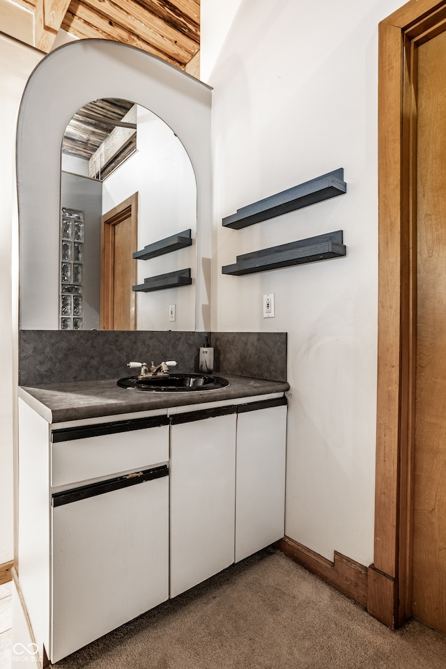 kitchen featuring dark colored carpet and sink