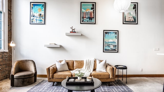 living area with brick wall and carpet flooring