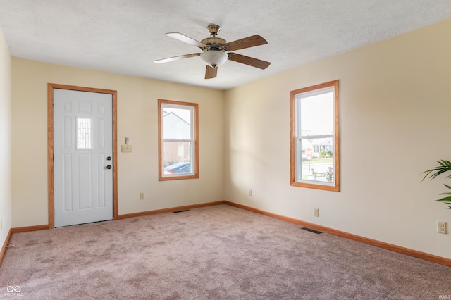 foyer entrance featuring visible vents, a healthy amount of sunlight, light carpet, and baseboards