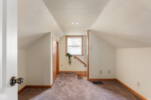 bonus room with light carpet, baseboards, visible vents, and vaulted ceiling