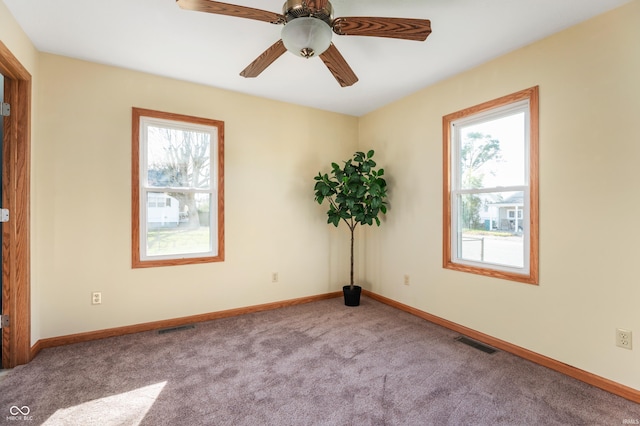 empty room featuring baseboards, visible vents, and light colored carpet