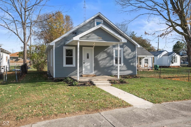 bungalow-style home with a front yard and fence