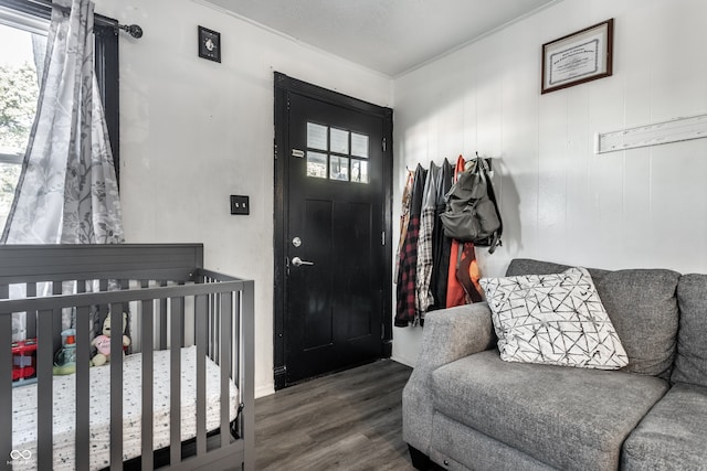 bedroom featuring wood-type flooring and a nursery area