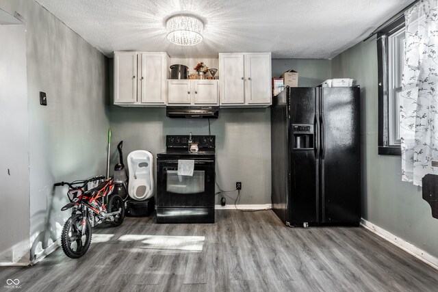 kitchen featuring hardwood / wood-style floors, white cabinets, exhaust hood, a textured ceiling, and black appliances