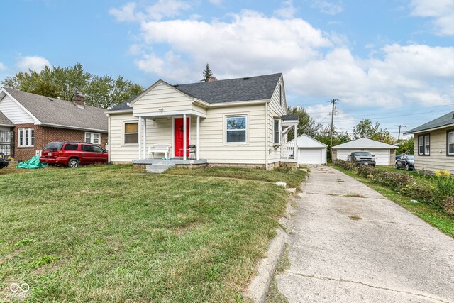 bungalow-style house featuring a front yard, an outbuilding, and a garage