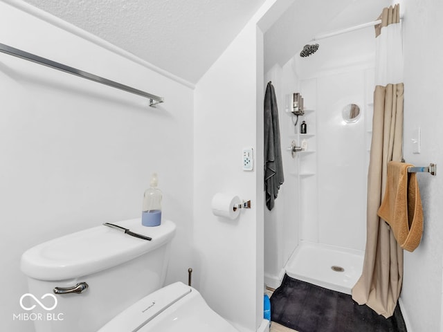 bathroom featuring a shower, a textured ceiling, and toilet