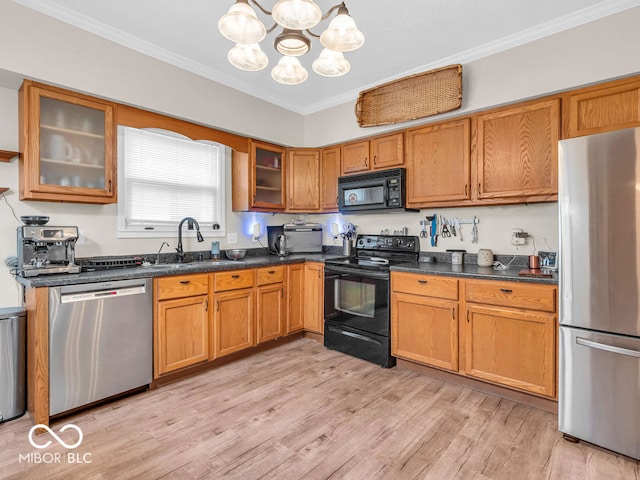 kitchen featuring light hardwood / wood-style flooring, an inviting chandelier, sink, black appliances, and pendant lighting