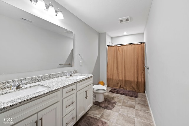 bathroom featuring tile patterned flooring, double sink vanity, and toilet