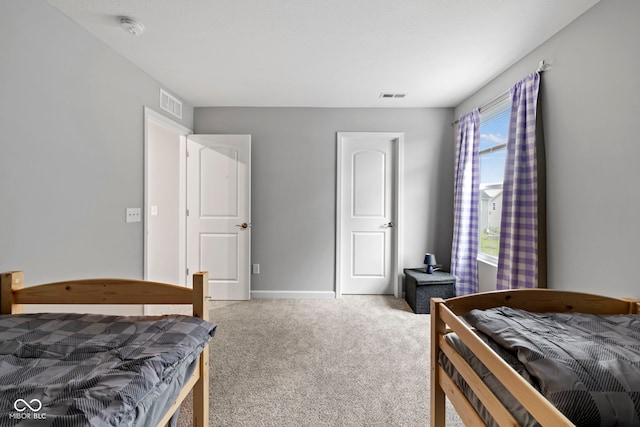 bedroom featuring light colored carpet and multiple windows