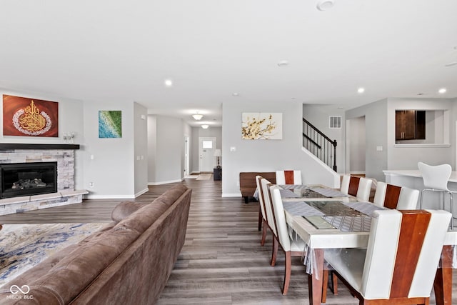 dining space with hardwood / wood-style flooring and a fireplace