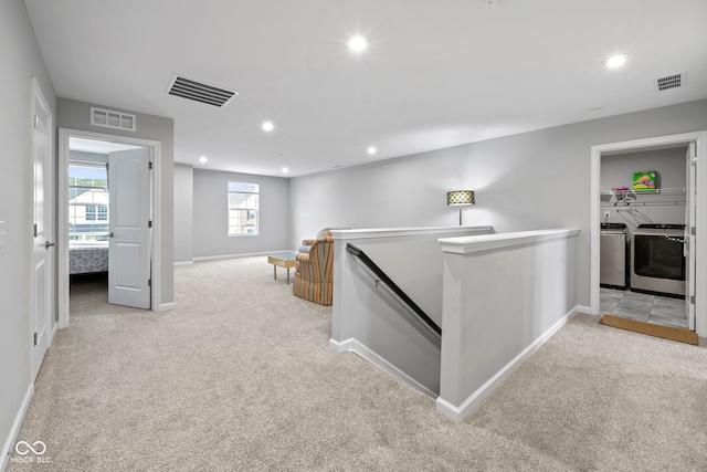 hallway featuring light carpet and washer and clothes dryer