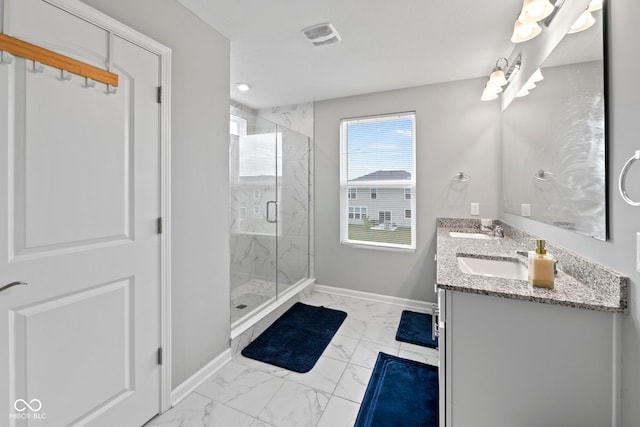 bathroom featuring a shower with shower door, dual bowl vanity, and tile patterned floors