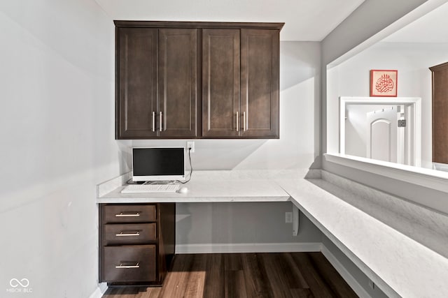 office featuring dark hardwood / wood-style flooring and built in desk