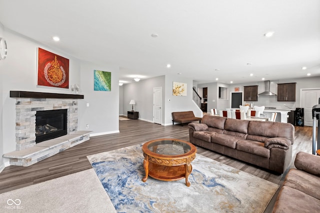 living room with hardwood / wood-style floors and a stone fireplace