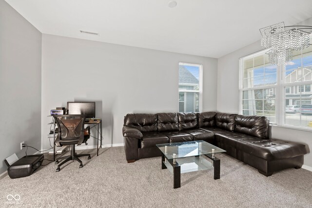 living room with carpet floors, an inviting chandelier, and a healthy amount of sunlight