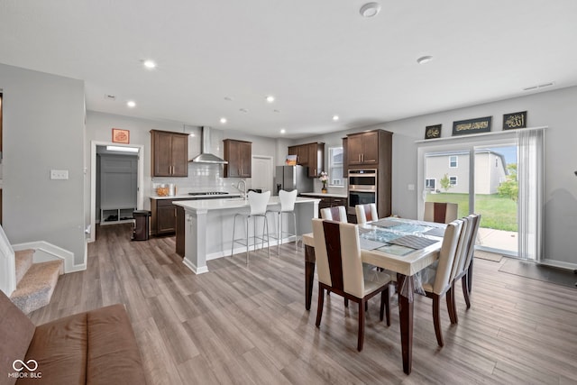 dining room featuring sink and light hardwood / wood-style floors