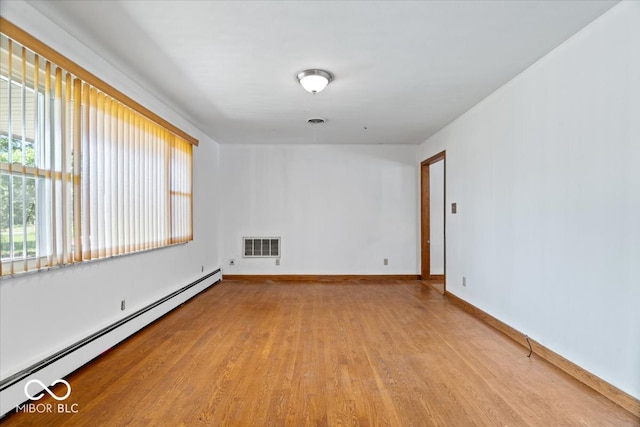 spare room with light hardwood / wood-style floors and a baseboard heating unit