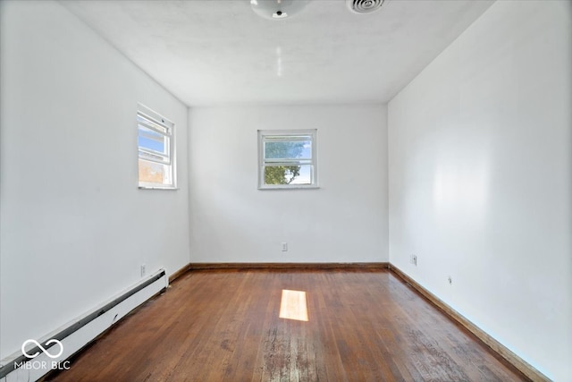 spare room with hardwood / wood-style flooring and a baseboard radiator