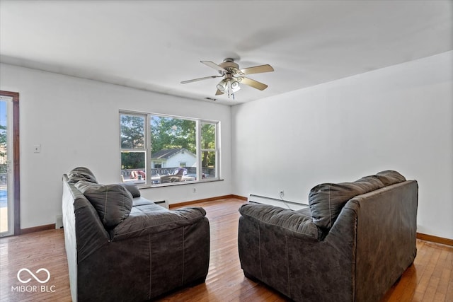 living room with hardwood / wood-style flooring, ceiling fan, and a baseboard heating unit