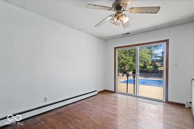 unfurnished room featuring hardwood / wood-style floors, ceiling fan, and a baseboard heating unit