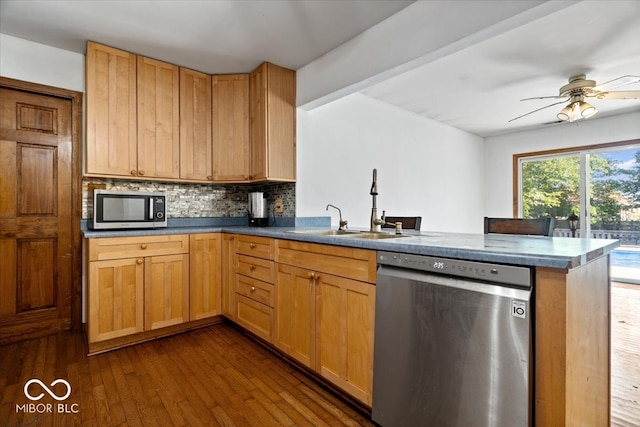 kitchen featuring kitchen peninsula, dark hardwood / wood-style floors, sink, and stainless steel appliances