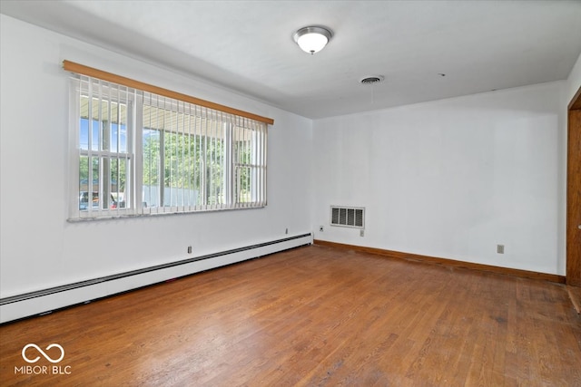 empty room with baseboard heating and hardwood / wood-style floors