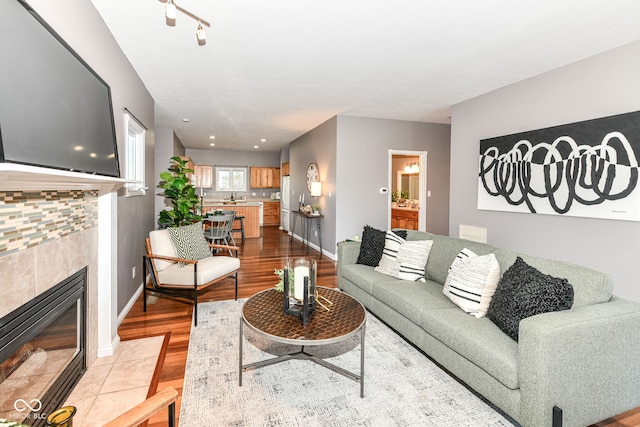 living room featuring light hardwood / wood-style floors and a tile fireplace