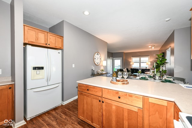 kitchen featuring white fridge with ice dispenser and dark hardwood / wood-style flooring