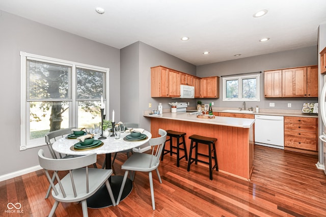 kitchen with a healthy amount of sunlight, wood-type flooring, and white appliances