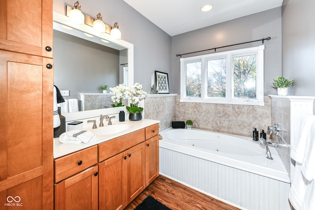 bathroom with vanity, a washtub, and hardwood / wood-style floors