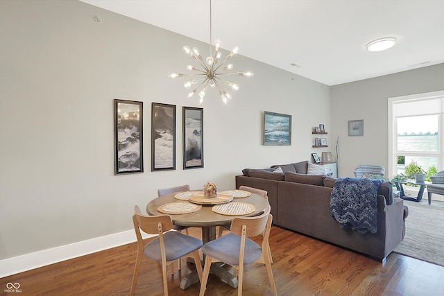 dining space featuring dark hardwood / wood-style flooring and an inviting chandelier